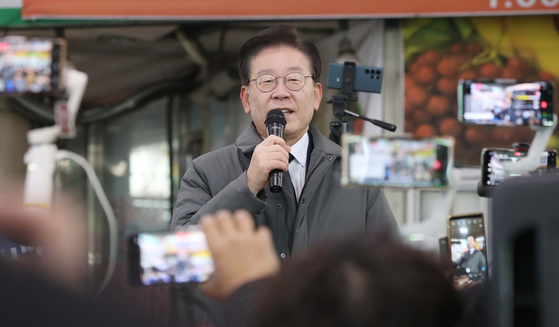 Democratic Party leader Lee Jae-myung delivers a speech at a traditional market in Andong, North Gyeongsang on Thursday, a day after prosecutors issued him a summons for questioning over bribery allegations involving Seongnam's football club. [YONHAP]