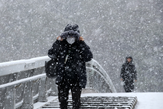 Heavy snow warnings were issued in Gwangju and South Jeolla region on Thursday morning. People walk in the snow to their workplaces in Seo District, Gwangju, on Thursday. [YONHAP] 