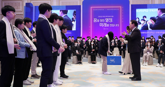 President Yoon Suk-yeol, far right, applauds after awarding commemorative plaques and prizes to the winners of the International Science Olympiad on Thursday during a meeting with science students held at the Blue House Yeongbingwan state guest house in central Seoul. President Yoon encouraged young science students during the meeting, stressing the importance of science as the ″level of a country matches its science level.″ A total of 140 students selected as recipients of the presidential science scholarship and 44 winners of the Olympiad were present. First lady Kim Keon-hee accompanied him for the hour-long meeting. [YONHAP] 