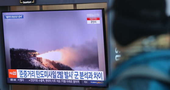 Passersby watch a televised news about North Korean military launch at the Seoul Station on Monday. [NEWS1] 