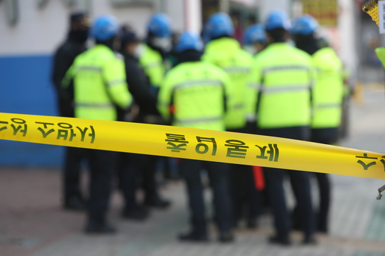 Firefighters and police officers inspect the scene of a fire in Sincheon-dong, Daegeu that killed one and injured two on Friday afternoon. [YONHAP] 