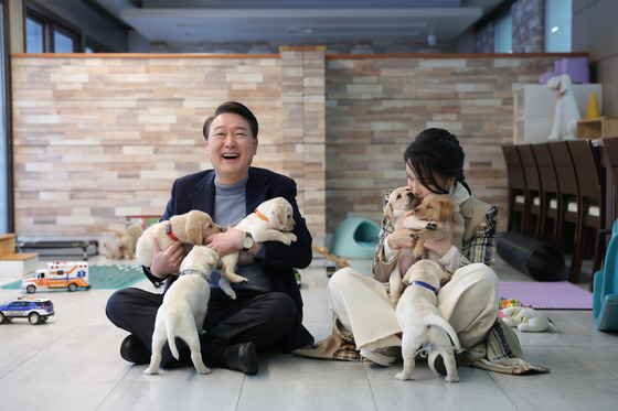President Yoon Suk-yeol, left, and first lady Kim Keon-hee spends time with dogs training at the Samsung Guide Dog School in Yongin, Gyeonggi on Saturday. [PRESIDENTIAL OFFICE]