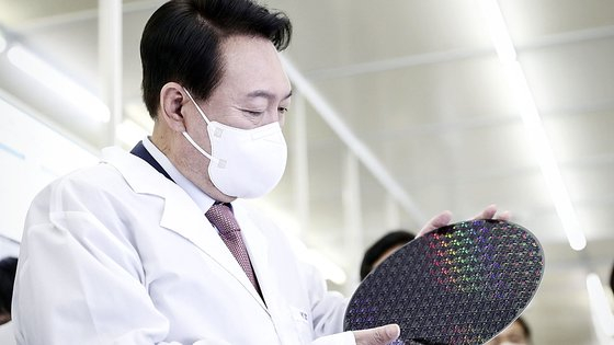  President Yoon Suk-yeol examines a wafer at the National Nanofeb Center situated within KAIST in Daejeon on April 29. [YONHAP]