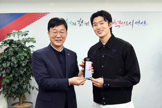 Korean footballer Cho Gue-sung, right, is awarded the Ansan Citizen's Happiness Award by Ansan Mayor Lee Min-Geun at Ansan City Hall in Ansan, Gyeonggi on Monday. Cho, who was born in Ansan, made a name for himself at the 2022 Qatar World Cup where a combination of his achievements on the pitch and his good looks caught the eye of fans around the world. During a game against Ghana, Cho became the first Korean ever to score multiple goals in a World Cup game.  [YONHAP]