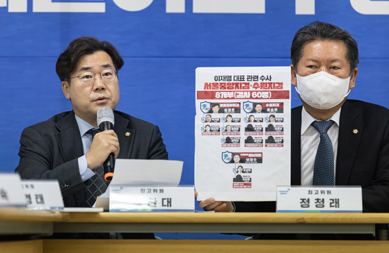 Democratic Party Rep. Park Chan-dae, left, a member of the party’s supreme council, reveals the names and faces of prosecutors who are conducting investigations related to DP Chairman Lee Jae-myung at a party meeting in Gangwon Friday. [NEWS1]