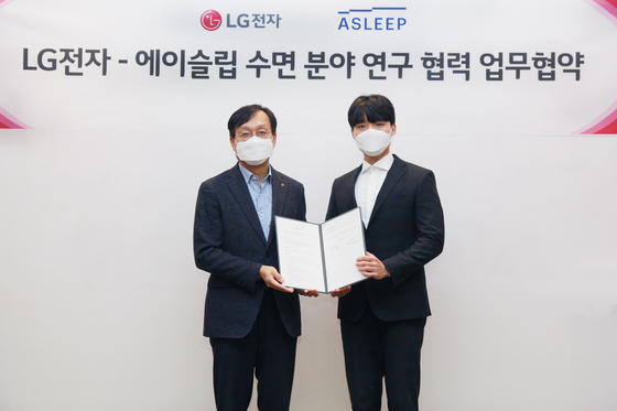 Oh Sai-kee, left, vice president at LG Electronics' Home and Appliance R&D Center, and Lee Dong-heon, CEO of Asleep, pose for a photo after signing an agreement to cooperate on developing home appliances that can help people to get better sleep, in Geumcheon District, southern Seoul, on Dec. 23. [LG ELECTRONICS]