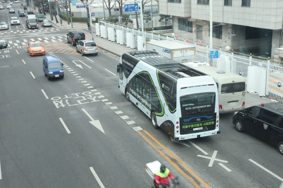 An electric self-driving bus, which has been deployed since last Thursday, passes in front of the government complex in central Seoul, Monday. [YONHAP]
