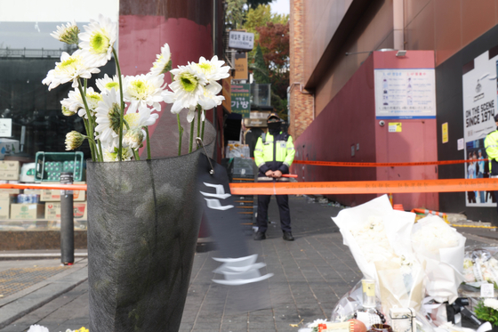 A police stands guard of the narrow alleyway behind Hamilton Hotel where many of the 158 people that died during Halloween weekend in Itaewon, Seoul, on Oct. 29 were found. [YONHAP] 
