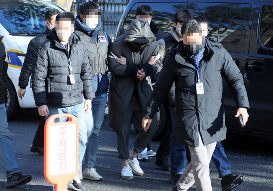 A 32-year-old man, who is suspected of murdering a taxi driver, as well as his ex-girlfriend, enters the Goyang branch of the Uijeongbu District Court to attend a hearing on Wednesday. [YONHAP]