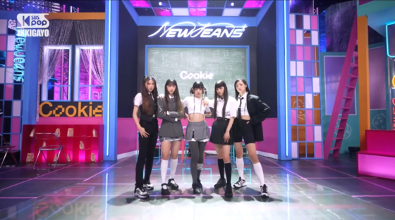 NewJeans wore a school uniform-inspired look for its live performance of ″Cookie,″ but most of the garments are from luxury fashion brands. [SCREEN CAPTURE]