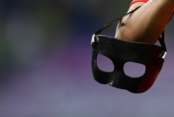 Son Heung-min holds his mask after a round of 16 match against Brazil at the 2022 Qatar World Cup in Doha, Qatar on Dec. 5.  [REUTERS/YONHAP]