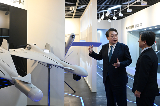 President Yoon Suk-yeol, left, is briefed on the development of South Korea’s unmanned aerial vehicles (UAV) in a visit to the Agency for Defense Development (ADD) in Daejeon Thursday. [PRESIDENTIAL OFFICE]