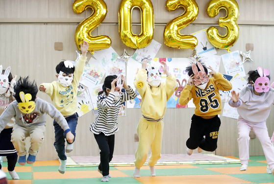 Children mimic rabbits with handmade rabbit masks to celebrate the Year of Rabbit at a daycare center in Gwangju on Thursday. [NEWS1]