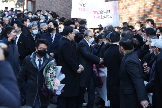 Former President Lee Myung-bak greets former colleagues and supporters in front of his house in Nonhyeon-dong, Seoul, on Friday. It was his first public appearance since being pardoned. [YONHAP]