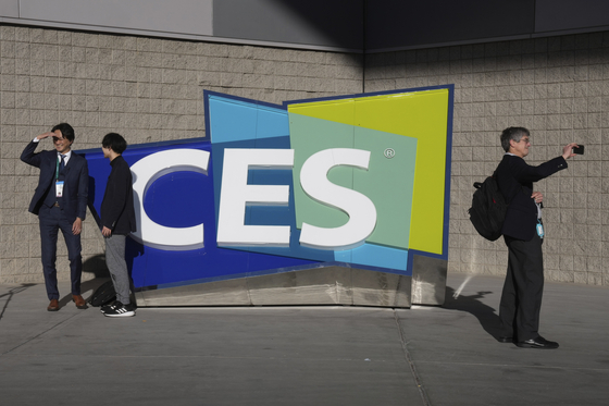 People take pictures in front of a sign during the CES tech show on Jan. 6, in Las Vegas. [AP/YONHAP]