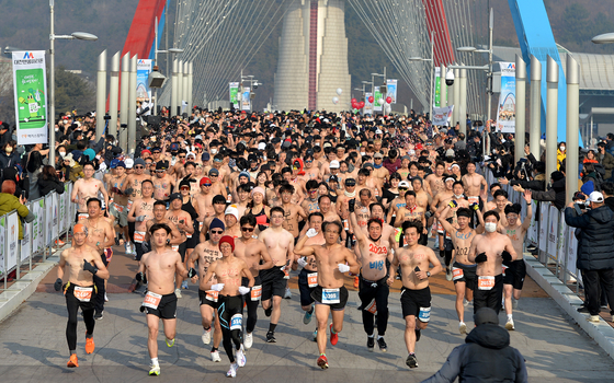 Runners take part in the 2022 Daejeon Bare Body Marathon at Daejeon Expo Science Park in Daejeon on Sunday. The annual event, which has been canceled for the last two years due to Covid-19, began in 2016 as a unique way to ring in the new year. The marathon, which is actually only 7-kilometers long, begins at 11:11 a.m. Despite the name, nobody in the Bare Body Marathon actually has an entirely bare body, with male participants going topless and female participants wearing sleeveless tops.  [JOONGANG ILBO]