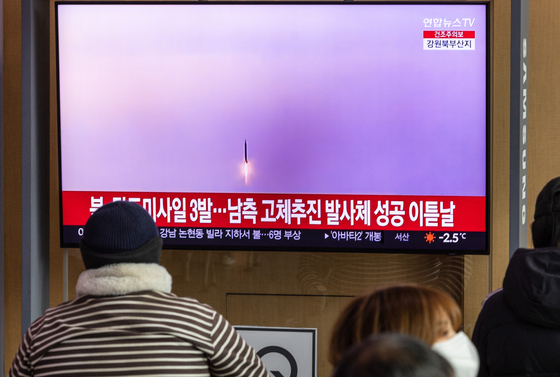 Passengers at Seoul Station watch a news broadcast about the North's missile salvo on Dec. 31. [YONHAP]