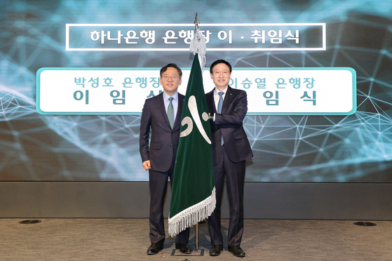 The newly appointed CEO of Hana Bank, Lee Seung-lyul, right, poses for a photo with former CEO Park Sung-ho at the inaugural ceremony in Jung District, central Seoul, on Monday. [YONHAP]