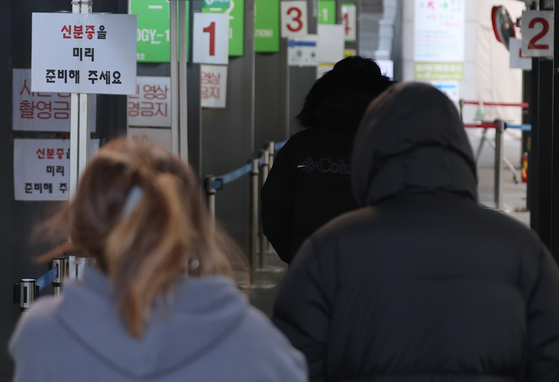 People wait in line to get tested for Covid-19 at a center in Yongsan District, central Seoul, on Monday. [YONHAP]