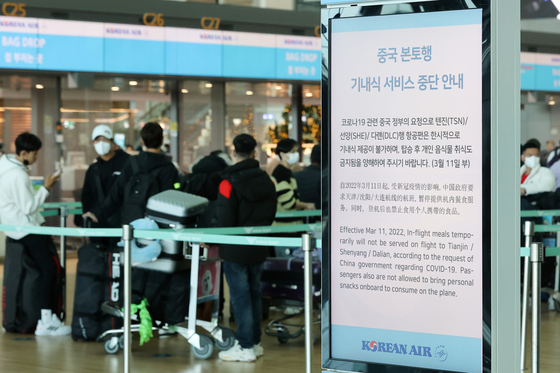A sign put up by the Korean Air at the Incheon airport on Friday informs travelers to China about meals no longer being served aboard the flights due to a request from the Chinese government citing Covid-19 concerns. All inbound travelers from China will be tested for Covid-19 upon arrival in Korea starting Monday. [NEWS1] 