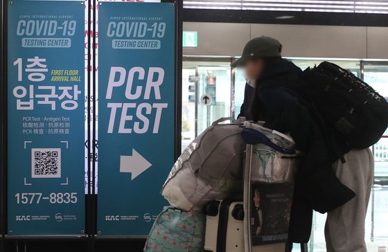 An arrival from abroad passes by banners that lead to Covid-19 testing centers at Gimpo International Airport on Dec. 29. [NEWS1] 