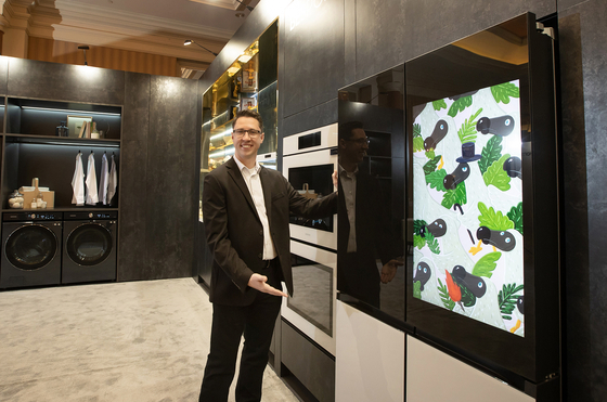 Damon Ekstam, a retail management manager at Samsung Electronics America, poses with a new Bespoke refrigerator. It features a Family Hub panel, which offers a 32-inch touchscreen that allows people to watch TVs, cue YouTube videos, or search for recipes. [SAMSUNG ELECTRONICS]
