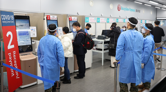 Health officials direct travelers from China registering for Covid-19 testing at Incheon International Airport on Tuesday. [YONHAP]