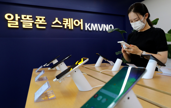A customer looks at a smartphone displayed at a mobile virtual network operator service center in Seoul. [NEWS1]