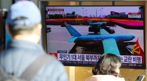 Passengers at Seoul Station watch a news broadcast about a North Korean drone flying into South Korea on Dec. 27. [YONHAP] 