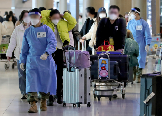 Arrivals from China are guided to PCR testing centers at Incheon International Airport on Wednesday. [YONHAP]