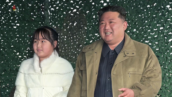 North Korean leader Kim Jong-un, right, and daughter Ju-ae watch the launch of a new Hwasong-17 ICBM at Pyongyang International Airport on Nov. 18 in a photo released by the North's official Korean Central News Agency on Nov. 19, 2022. [YONHAP]