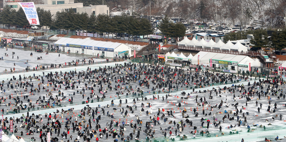 Visitors flock to the 2023 Hwacheon Sancheoneo Ice Festival in Hwacheon, Gangwon, on Sunday, the first time the event has resumed in three years. The festival kicked off Saturday and will run through Jan. 29. The 2020 festival did not take place due to a warm winter and the 2021 and 2022 editions were canceled due to the Covid-19 pandemic. Sancheoneo is a Korean mountain trout. [YONHAP]