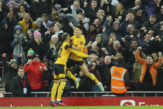 Wolverhampton Wanderers' Hwang Hee-chan, right, celebrates after scoring his side's second goal during an FA Cup match against Liverpool at Anfield in Liverpool, England on Saturday.  [AP/YONHAP]