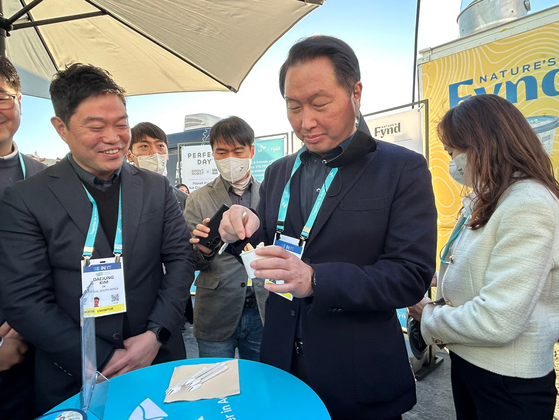 SK Group Chairman Chey Tae-won tastes a planet-friendly mint-chocolate ice cream at CES 2023 in Las Vegas on Friday. [SARAH CHEA]