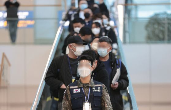 Travelers arriving from China being escorted for PCR testing at Incheon International Airport on Monday. [YONHAP] 