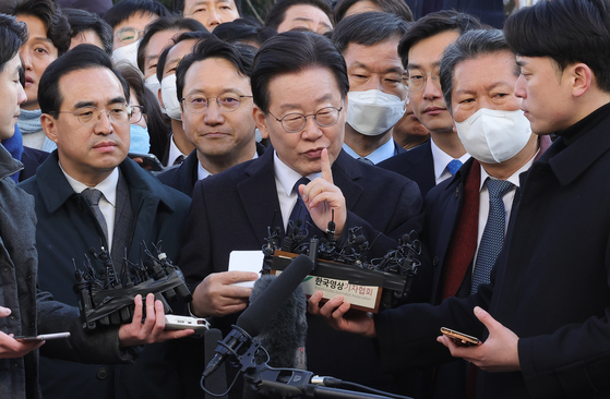With senior Democratic Party lawmakers behind him, DP Chairman Lee Jae-myung delivers remarks after arriving at the Seongnam branch of the Suwon District Prosecutors' Office on Tuesday morning. [YONHAP]