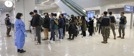 People arriving from China being tested for Covid-19 at Incheon International Airport on Monday. [YONHAP] 
