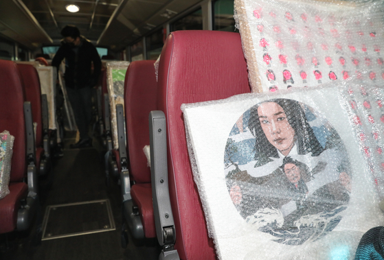 A satiric political painting with the likenesses of President Yoon Suk Yeol and first lady Kim Keon-hee is seen on a bus in front of the National Assembly on Tuesday. A Democratic Party lawmaker tried to hold a political satire exhibition with some 80 paintings, but the National Assembly’s office decided not to allow it, saying it was offensive. [NEWS1] 
