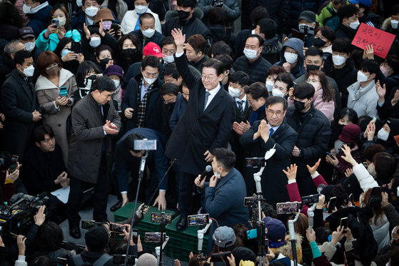 Democratic Party chairman Lee Jae-myung surrounded by supporters at a market in Incheon Wednesday. [NEWS1]