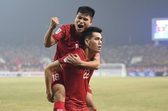 Vietnam's Nguyen Quang Hai celebrates with his teammate during a semifinal match against Indonesia at the AFF Championship in Hanoi, Vietnam on Monday.  [AP/YONHAP]