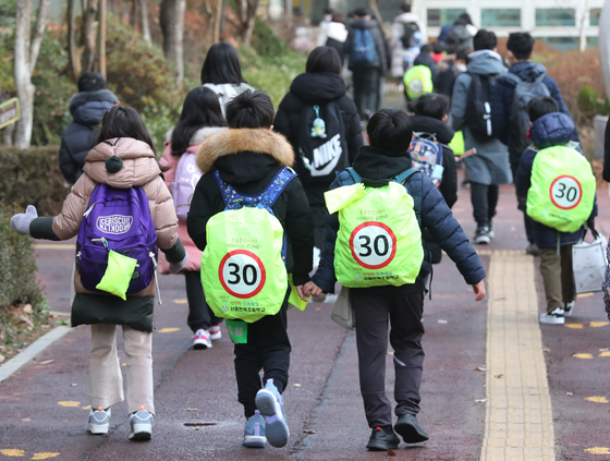 Students go to school with backpacks with 30-kilometer-per-hour speed limit reminders at Eonbuk Elementary School in Gangnam District, southern Seoul on Dec. 13 after a third-grade student named Lee Dong-won died in a school zone accident. [NEWS1]