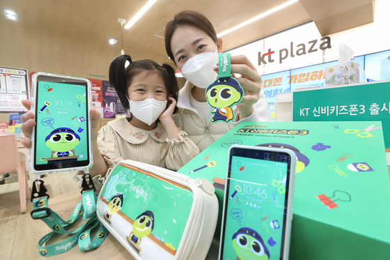 Models display KT's new LTE smartphone for kids, the KT Shinbi Kids Phone 3, on Thursday. The sale of the phone will begin Friday. [YONHAP].