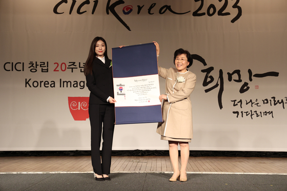 Figure skater Kim Yuna, left, and Choi Jung-hwa, president of the Corea Image Communication Institute, hold up an award during the annual Korea Image Awards 2023 on Wednesday evening. Kim was given the Korea Image Cornerstone Award. [CICI]