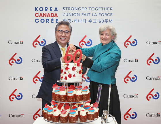 Foreign Minister Park Jin, left, and Chargee d'affaires of Canada to Korea Tamara Mawhinney celebrate the 60th anniversary of Korea-Canada relations at the Canadian Embassy in Seoul on Thursday. [PARK SANG-MOON]