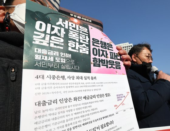 Members of the Progressive Party hold a press event in front of Shinhan bank’s headquarter in Jung District, central Seoul, requesting the banks to reduce the interest rates for loans. [YONHAP]
