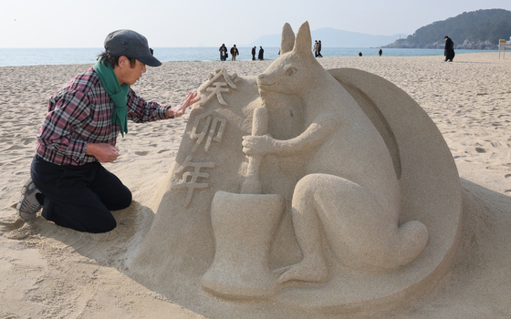 Sand sculptor Kim Gil-man creates a rabbit sand sculpture on Jan. 1 to celebrate the Year of the Black Rabbit. [SONG BONG-GEUN]