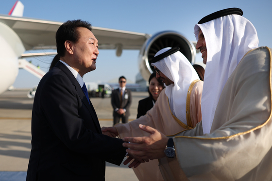 President Yoon Suk Yeol shakes hands with United Arab Emirates (UAE) officials after arriving at Abu Dhabi International Airport in Abu Dhabi on Sunday. [YONHAP]
