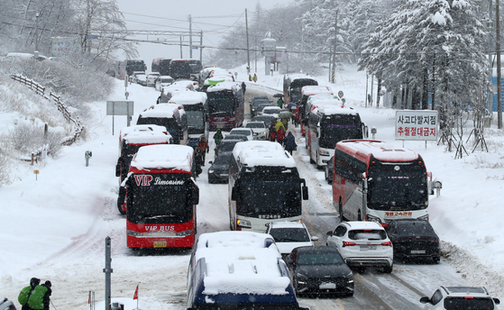 A highway in Pyeongchang County, Gangwon, is packed with cars and buses carrying hiking tour groups flocking to the snowy mountains of Gangwon on Sunday. [YONHAP] 