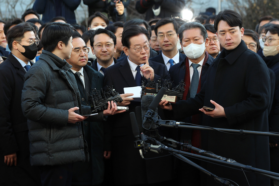 With senior Democratic Party lawmakers behind him, DP Chairman Lee Jae-myung delivers remarks after arriving at the Seongnam branch of the Suwon District Prosecutors' Office on Tuesday morning. [NEWS1] 