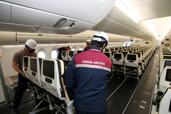 Asiana Airlines restored all seven of its cargo aircraft — four A350s and three A330s — back to passenger aircraft, according to the airline Monday. The photo shows Asiana Airlines employees re-equipping the renovated aircraft with passenger seats. [YONHAP]